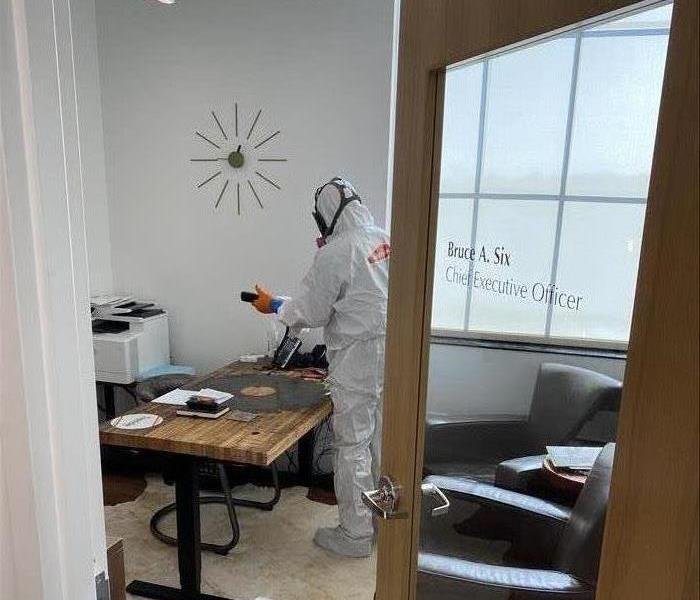 Office space has been contaminated with Covid 19. A SERVPRO technician carefully disinfects all the surfaces. 